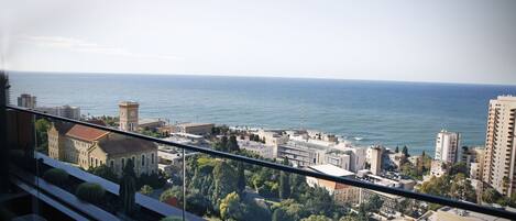 A cityscape with a view of the sea, buildings, and a clock tower.