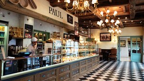 A bakery with a checkered floor and a sign reading "PAUL". - 1866 Court & Suites (Beirut)