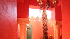 A corridor with red walls, white columns, and a chandelier. - Afei Surf Inn - Hall 3 (Hengchun)