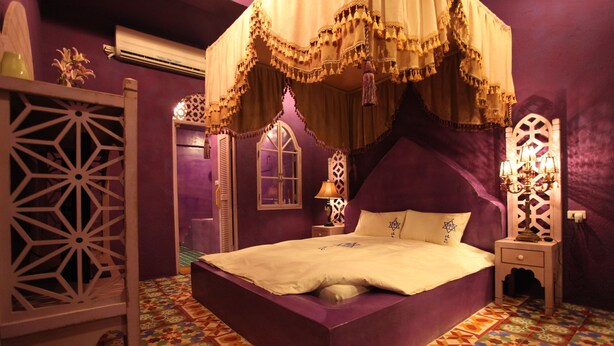 A room with a large bed, purple walls, and patterned floor tiles. - Afei Surf Inn - Hall 3 (Hengchun)