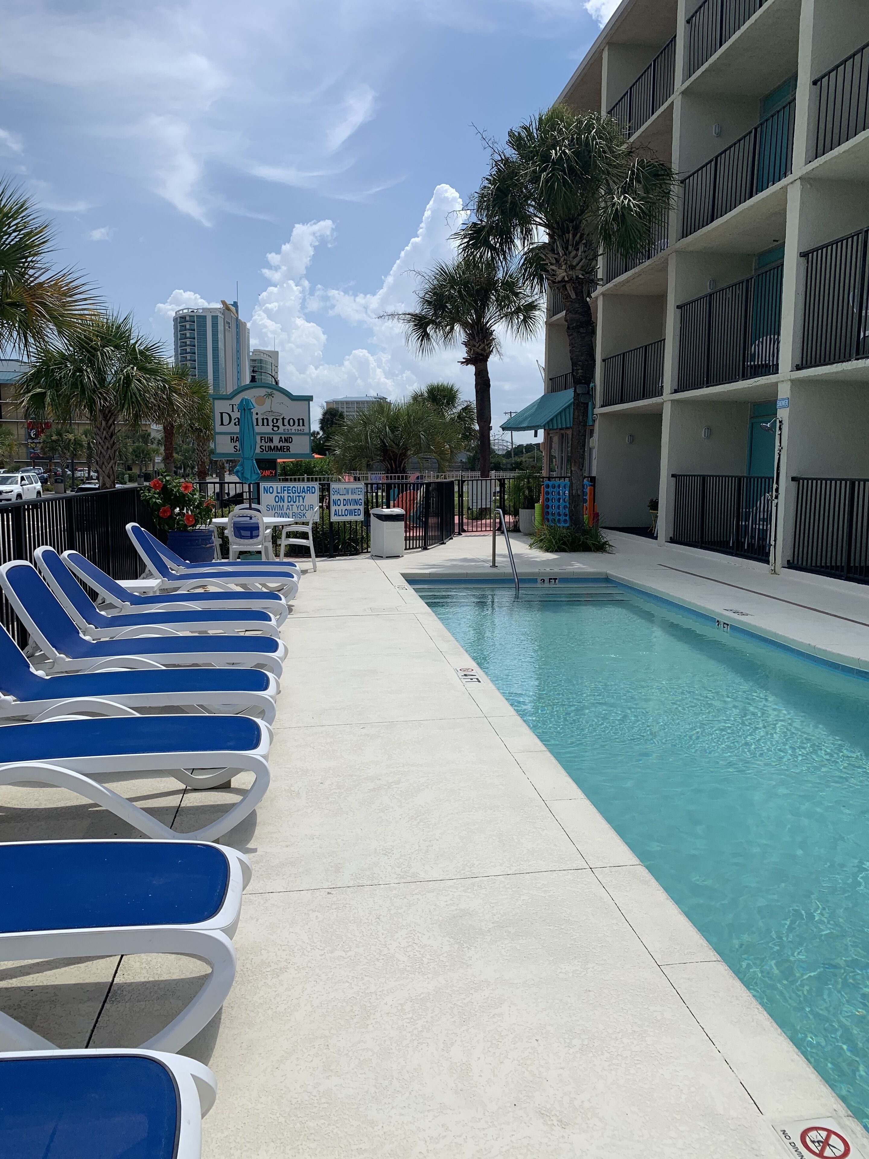 A poolside area with lounge chairs and a sign indicating no diving.