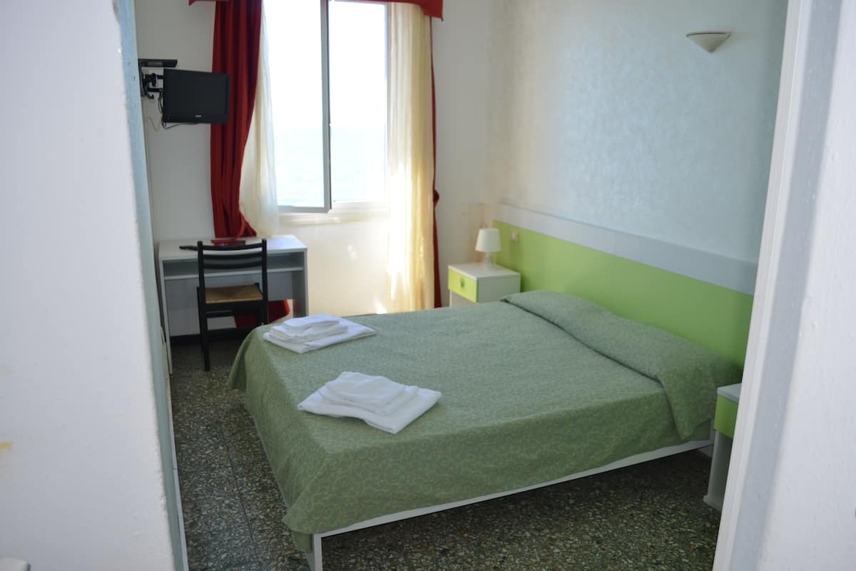 A room with a bed, a desk, and a chair.