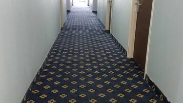 A long, narrow hallway with a patterned carpet and light-colored walls.