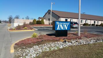A Briarwood Inn sign in front of a building with a parking lot.
