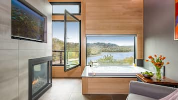 Enjoy a serene lake view from the large window, with a fireplace and bathtub for a relaxing retreat.