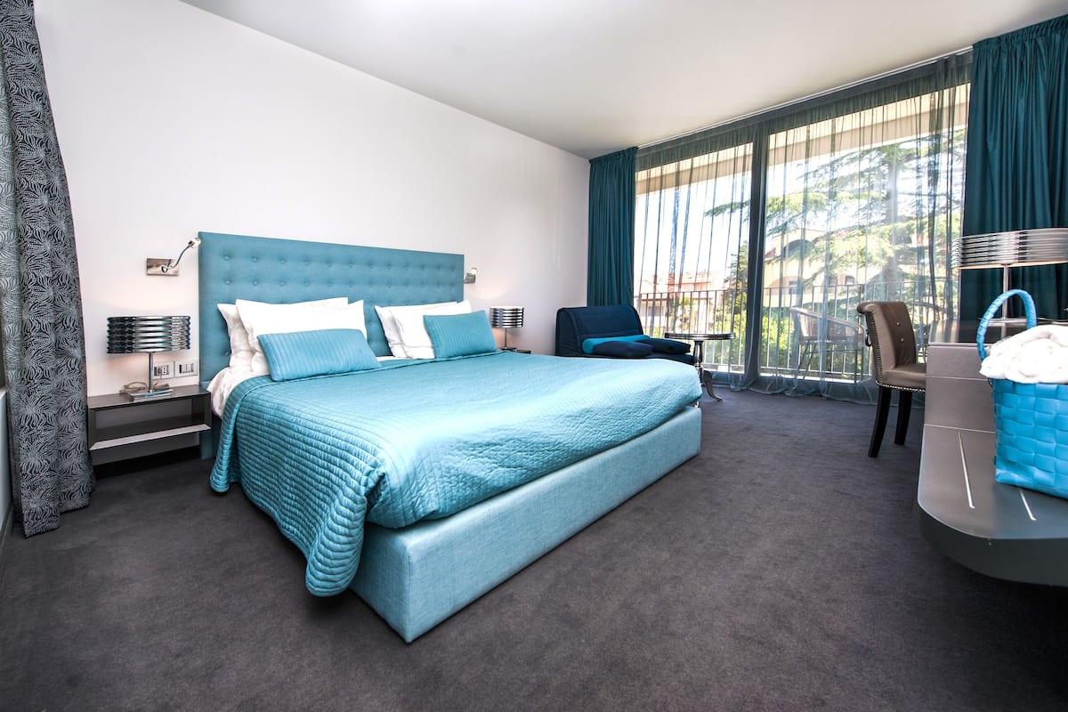 Ein modernes Hotelzimmer mit einem großen Bett, einem Schreibtisch und einem Sessel.