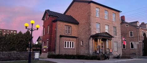 A brick building with a prominent entrance, a signboard, and a street lamp.