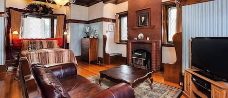 Una sala de estar con un sofá de cuero, una mesa de centro, una chimenea y un televisor.