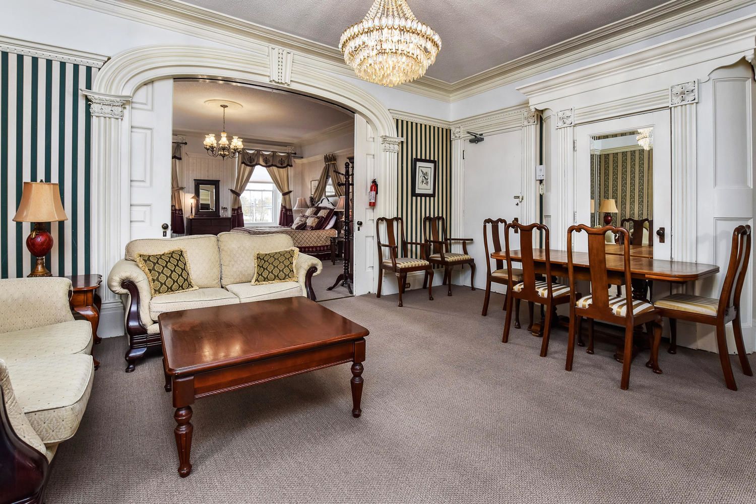 A spacious living room with a sofa, coffee table, and dining table set.