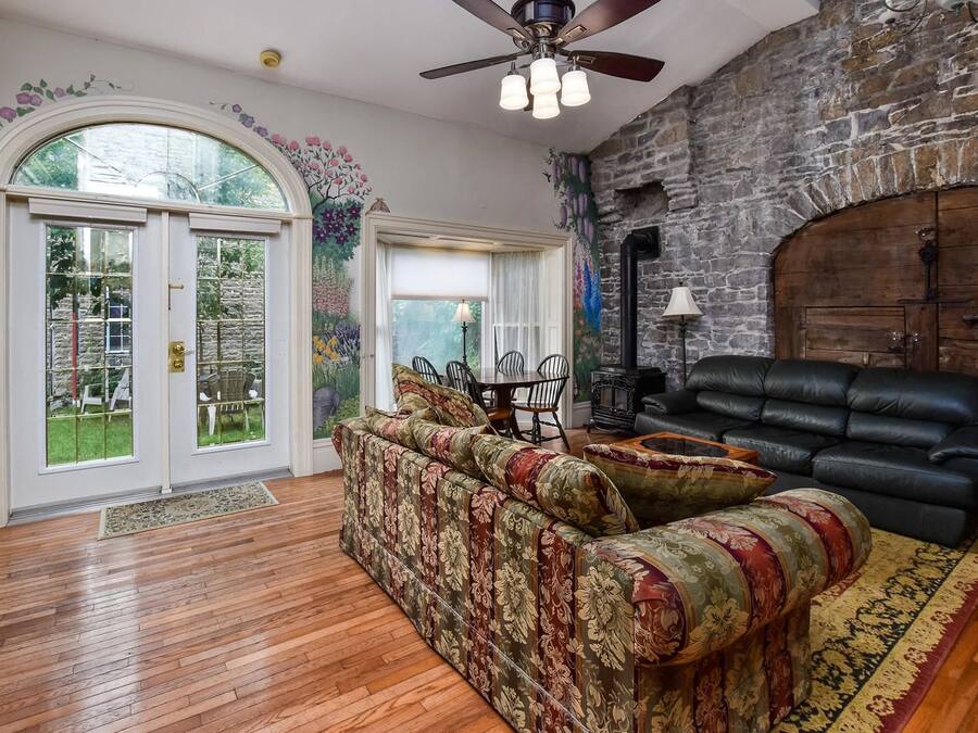 A living room with a fireplace, a sofa, and a dining area with chairs.