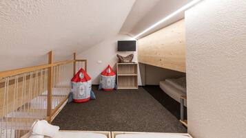 Cozy playroom with a bunk bed, TV, and toys.