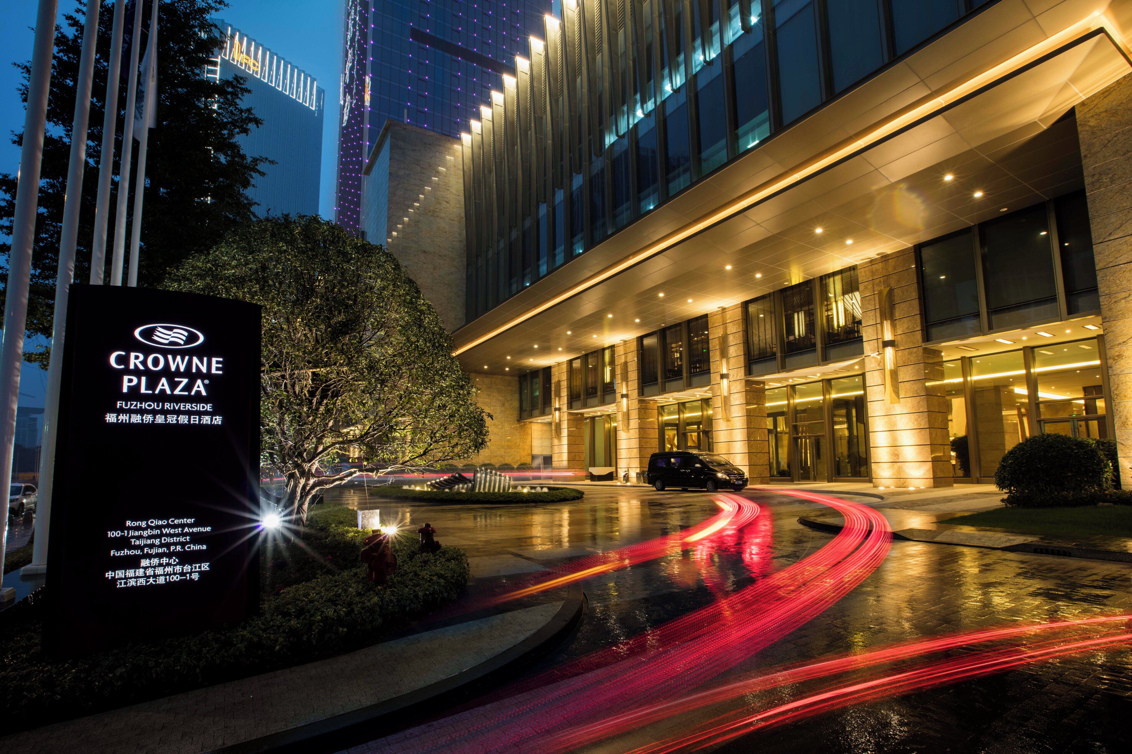A modern hotel entrance with a sign for Crowne Plaza Fuzhou Riverside.