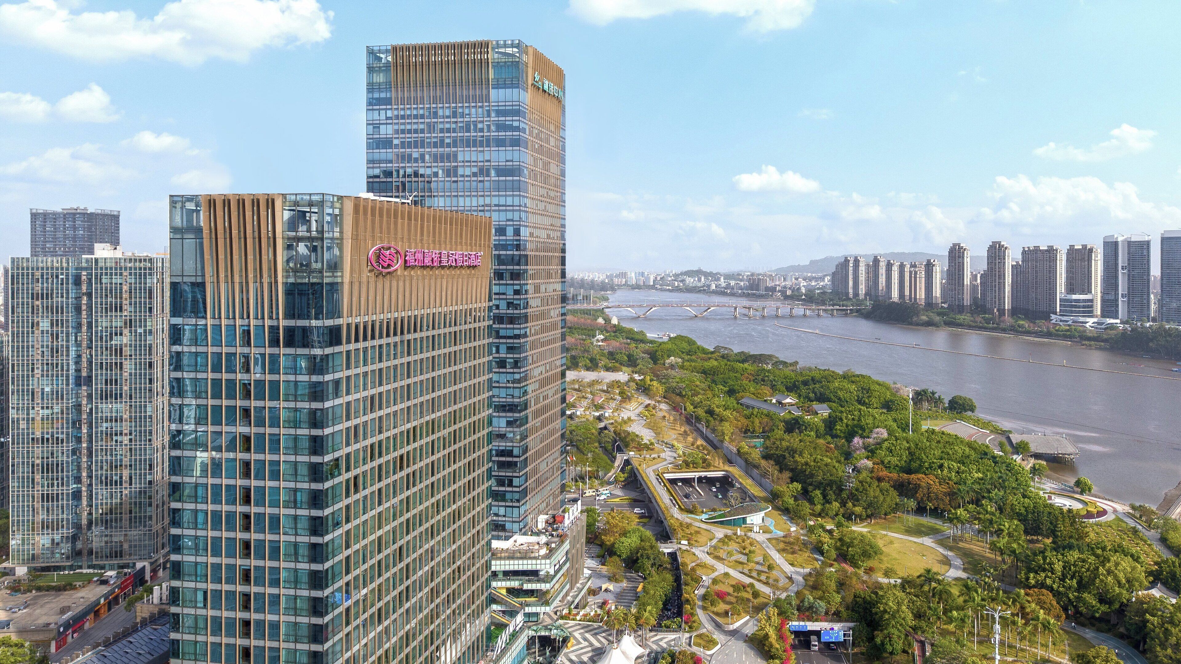 A high-rise building with a modern glass facade and a prominent logo on the side.