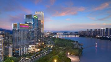 Located in a bustling urban area, this high-rise building offers stunning views of a nearby park and serene waterway.