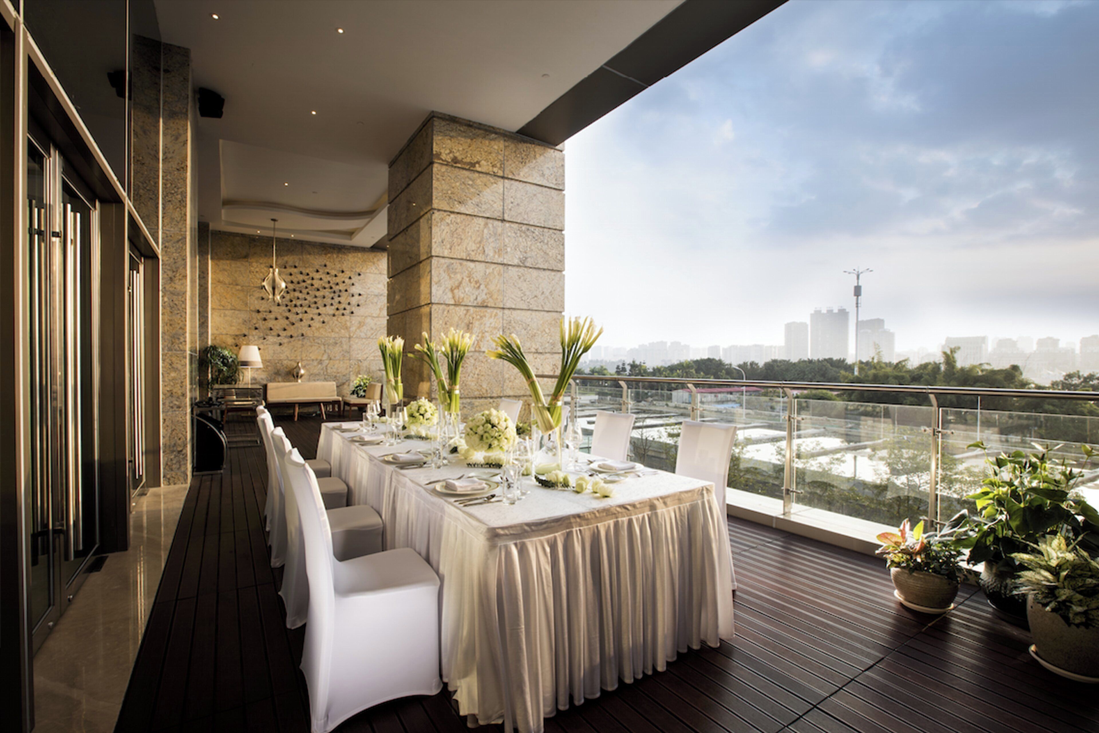 A dining area with a table set for six, overlooking a cityscape.