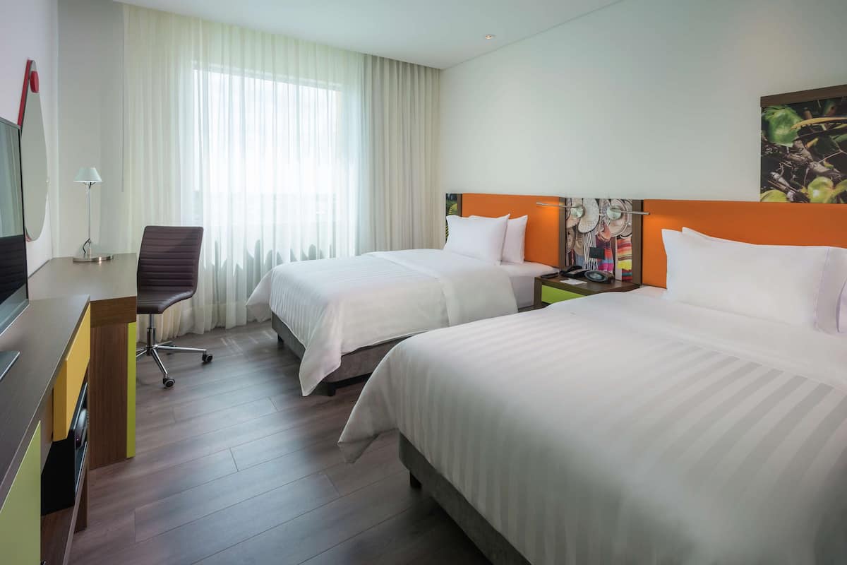 Ropa de cama hipoalergénica y caja de seguridad en la habitación
