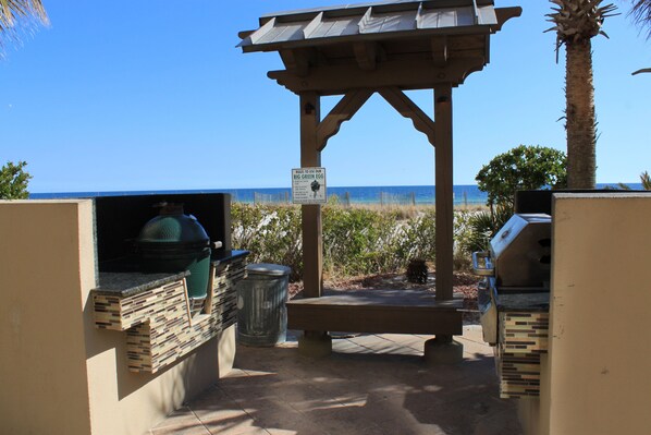An outdoor barbecue area with a grill and a sign about using the grill.