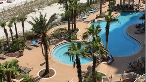 A resort with a pool area, palm trees, and a beach. - Indigo by Luxury Coastal Vacations (Pensacola)