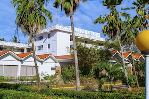 A hotel with a white facade, red-tiled roofs, and a balcony with a railing. - Mombasa Beach Hotel (Mombasa)