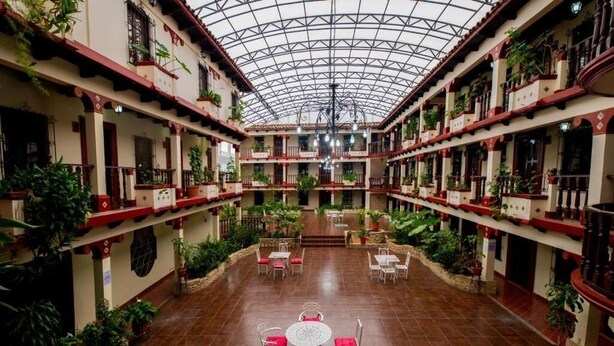 A spacious atrium with a high ceiling, multiple balconies, and potted plants. - Hotel D' Monica  (San Cristóbal de las Casas)