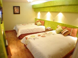 Una habitación de hotel con dos camas, cada una con una almohada y una mesita de noche con teléfono.