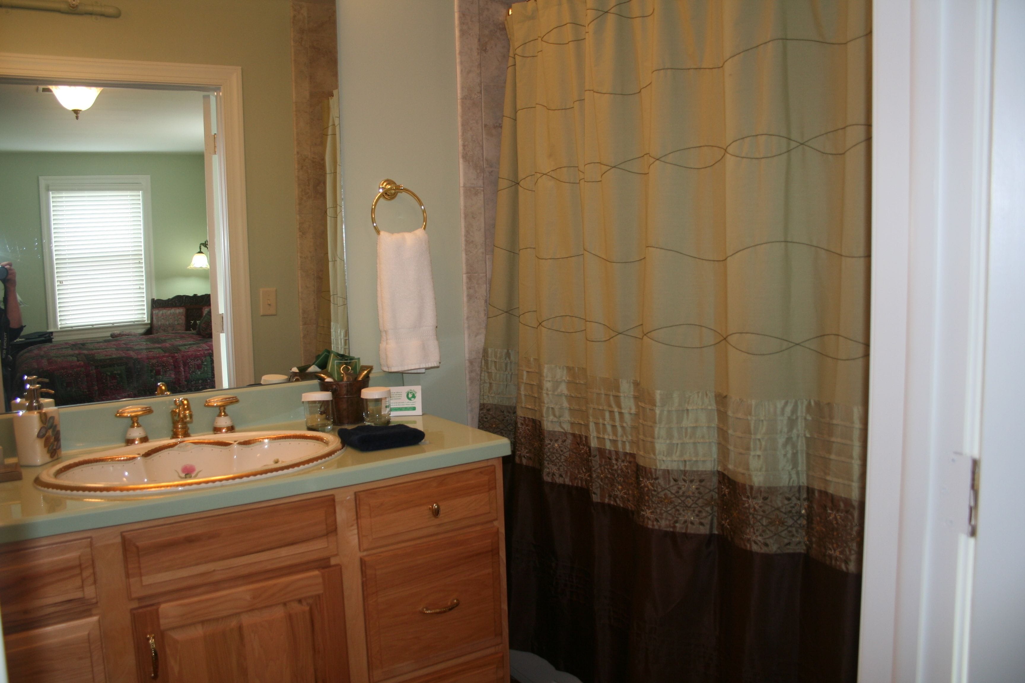 A bathroom with a sink, mirror, and towel rack.