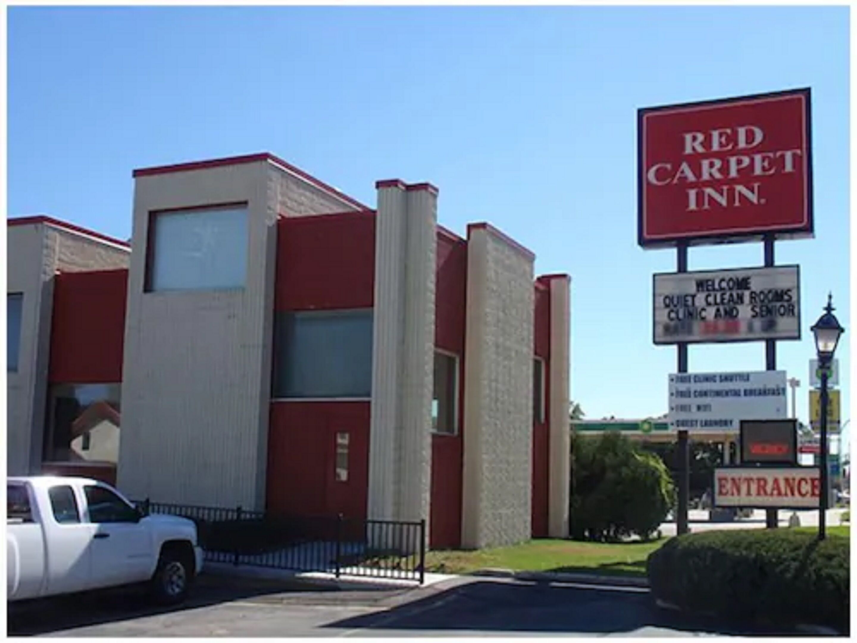 A Red Carpet Inn with a sign indicating quiet, clean rooms, a clinic, and senior services.