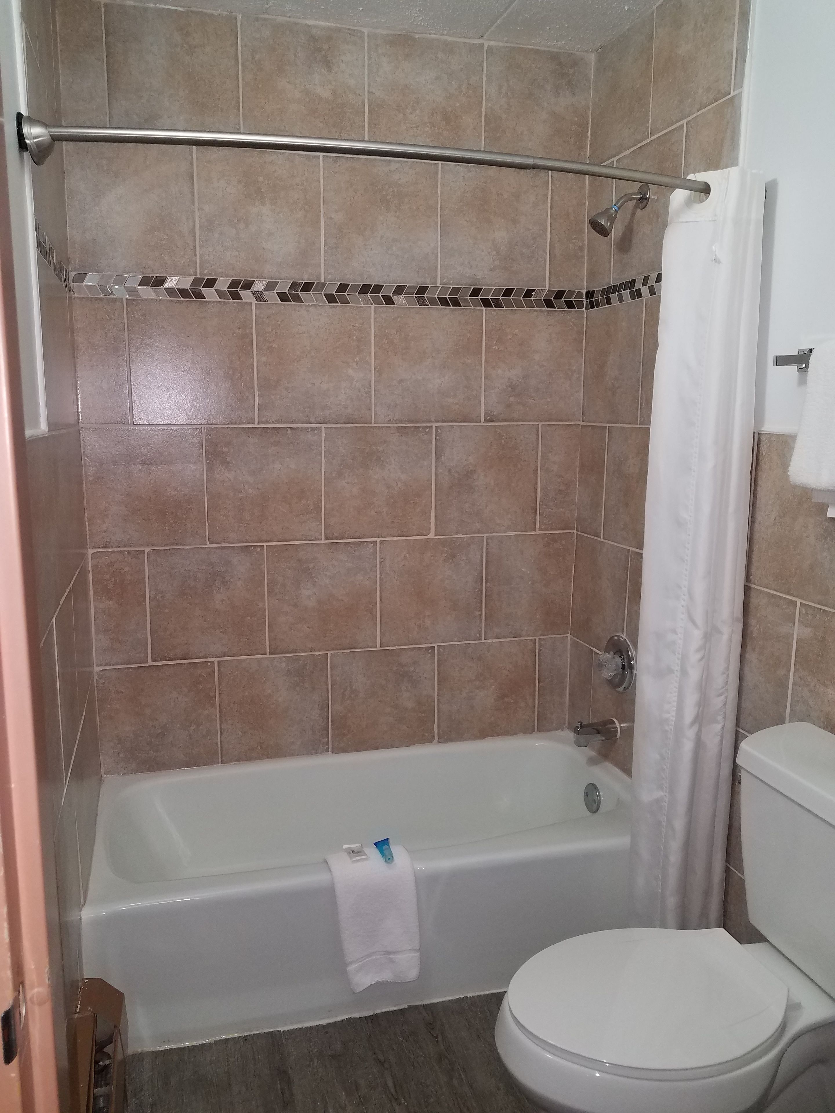 Une salle de bain avec une baignoire, des toilettes et un rideau de douche.