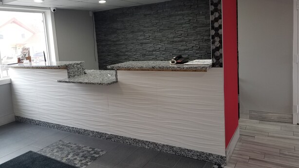 A reception area with a stone wall, a marble counter, and a red accent wall.