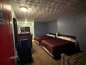 Une chambre dâhĂŽtel avec deux lits, un bureau, une chaise et une porte rouge.