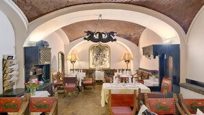 A restaurant with arched ceilings, wooden chairs with dragon designs, and tables set for dining. - Hotel Embassy (Karlovy Vary)