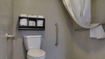 A bathroom with a toilet, a shelf with towels, a shower curtain, and a grab bar.