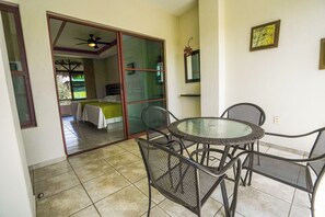 Une pièce avec un lit, une table en verre et des chaises.