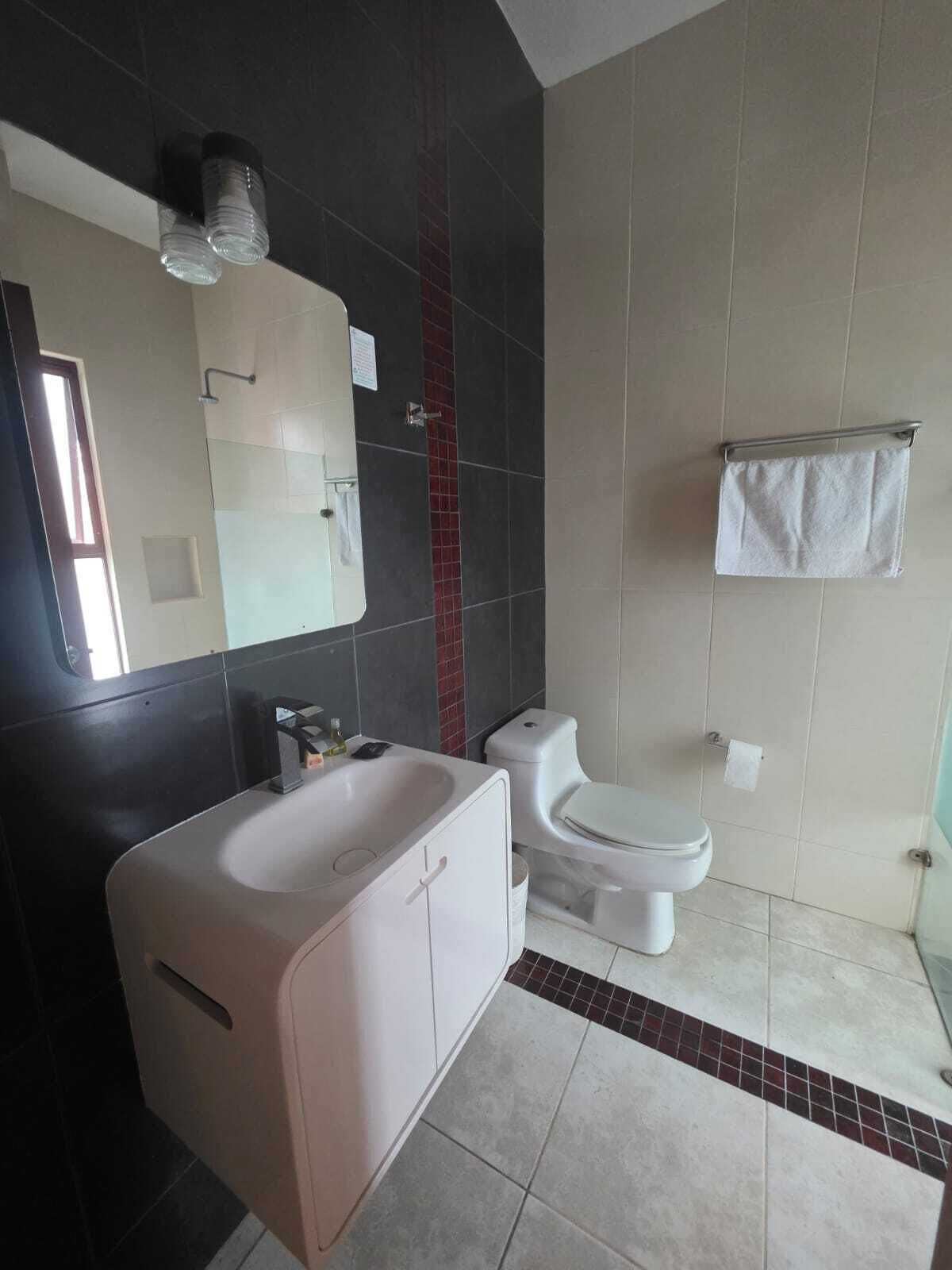 Une salle de bain moderne avec une baignoire blanche, des toilettes et un porte-serviettes.