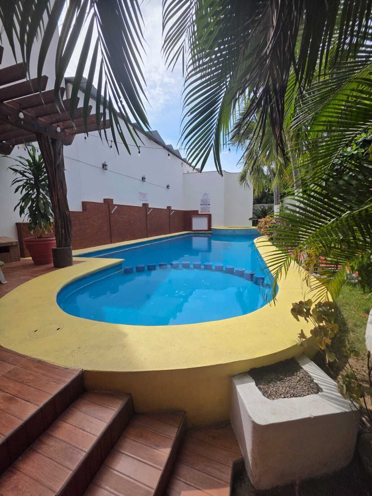 Una piscina al aire libre, sillones reclinables de piscina