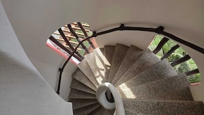 A spiral staircase with a white handrail and a black metal balustrade. - Hotel y Suites Los Encantos (Sayulita)