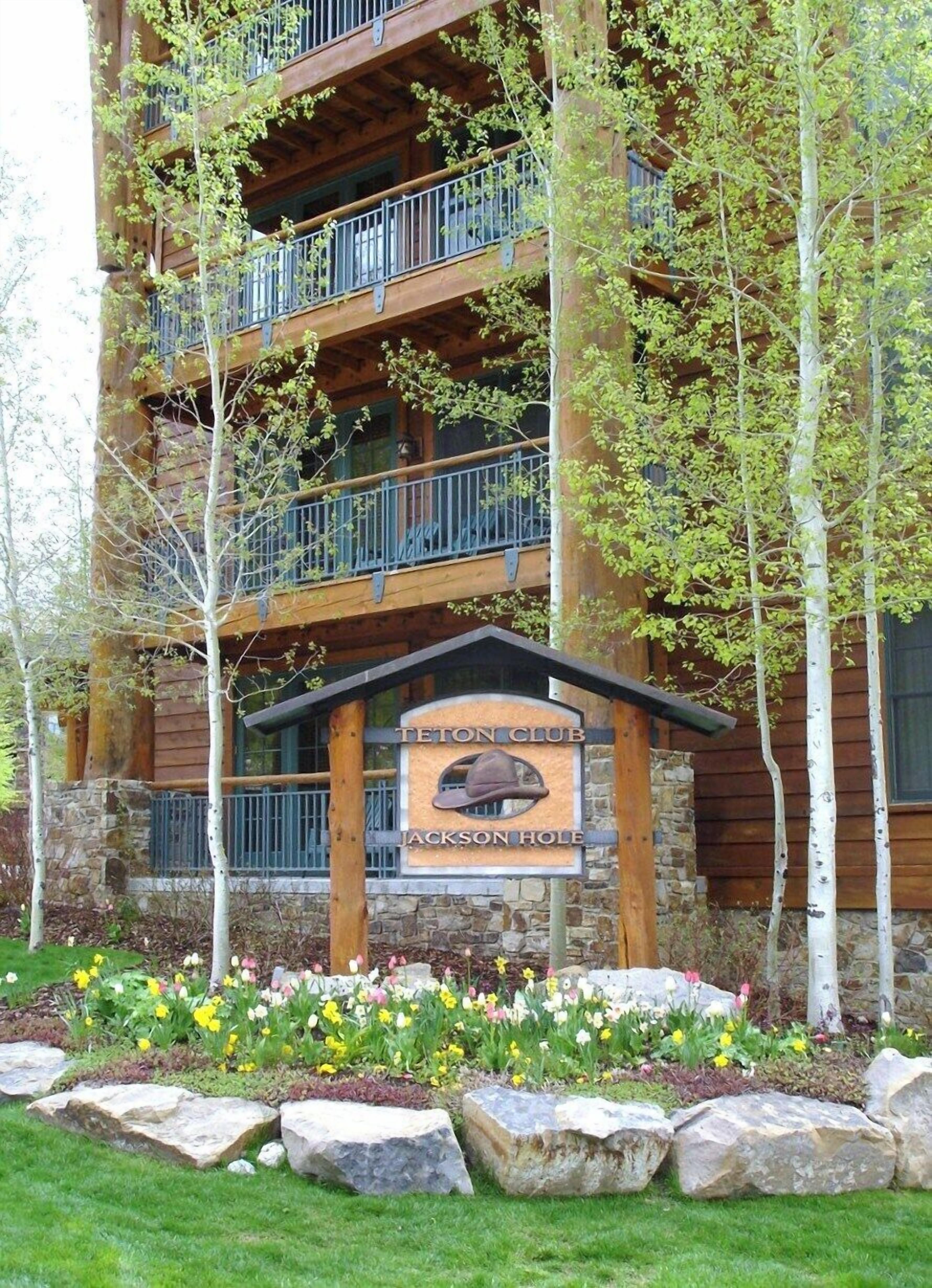 A multi-story building with a sign reading "Teton Club Jackson Hole."