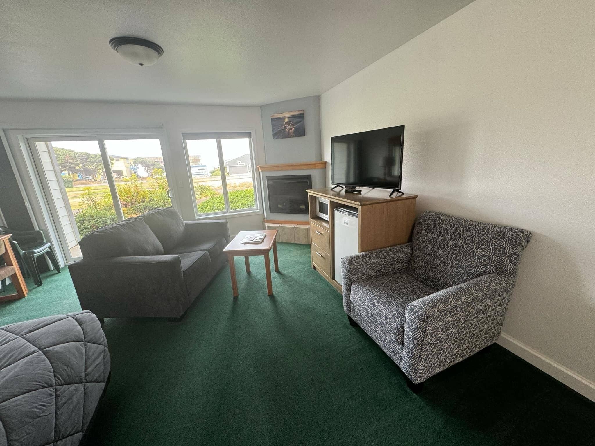 standard studio, 2 queen beds, patio, partial ocean view | living area | 41-inch flat-screen tv with cable channels, books