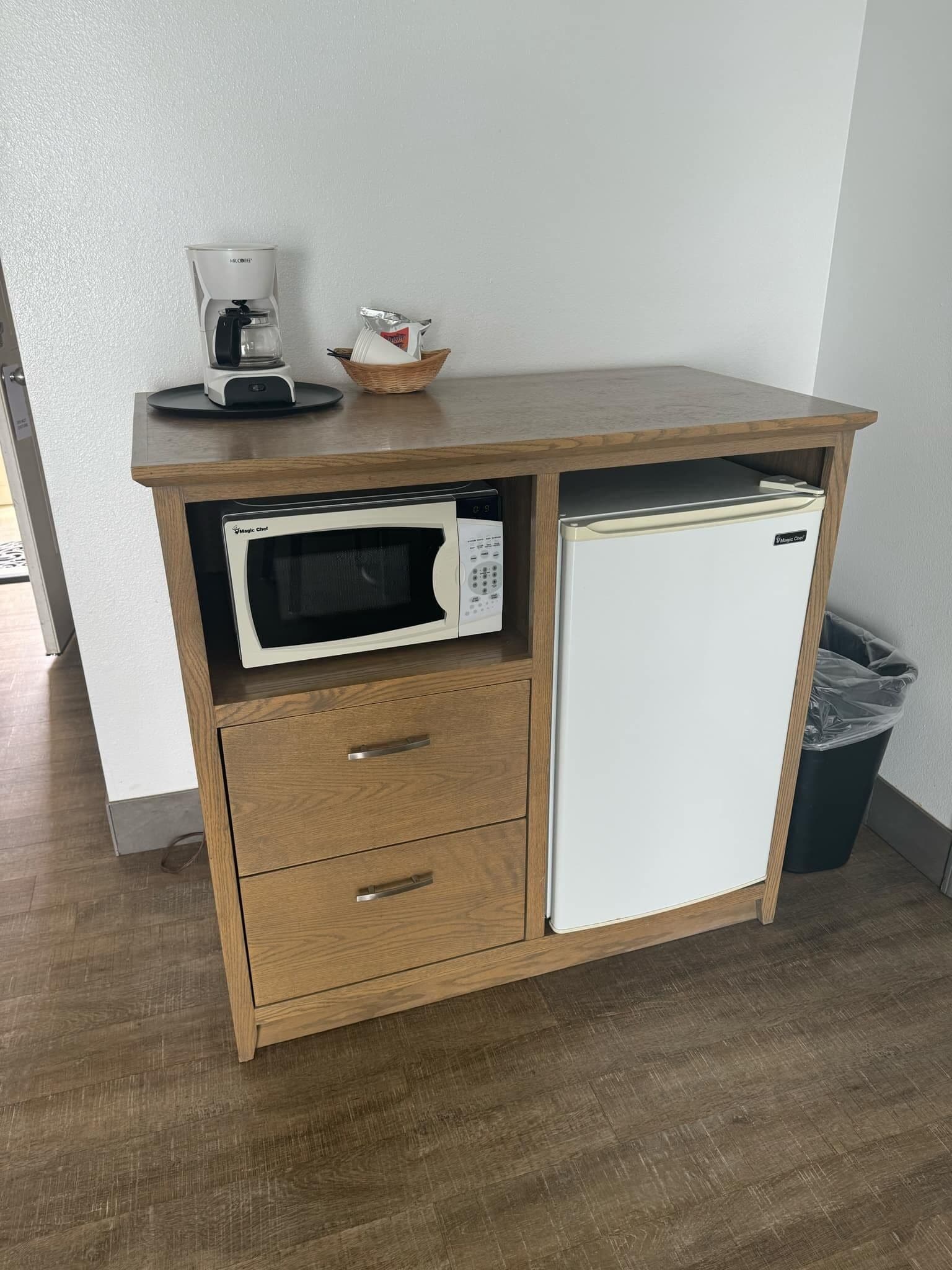 A kitchenette with a microwave, a coffee maker, and a refrigerator.