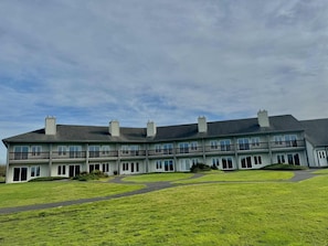 A multi-story building with a flat roof, large windows, and a central courtyard.