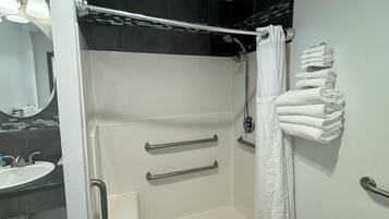 A modern bathroom with a walk-in shower, a toilet, and a sink.