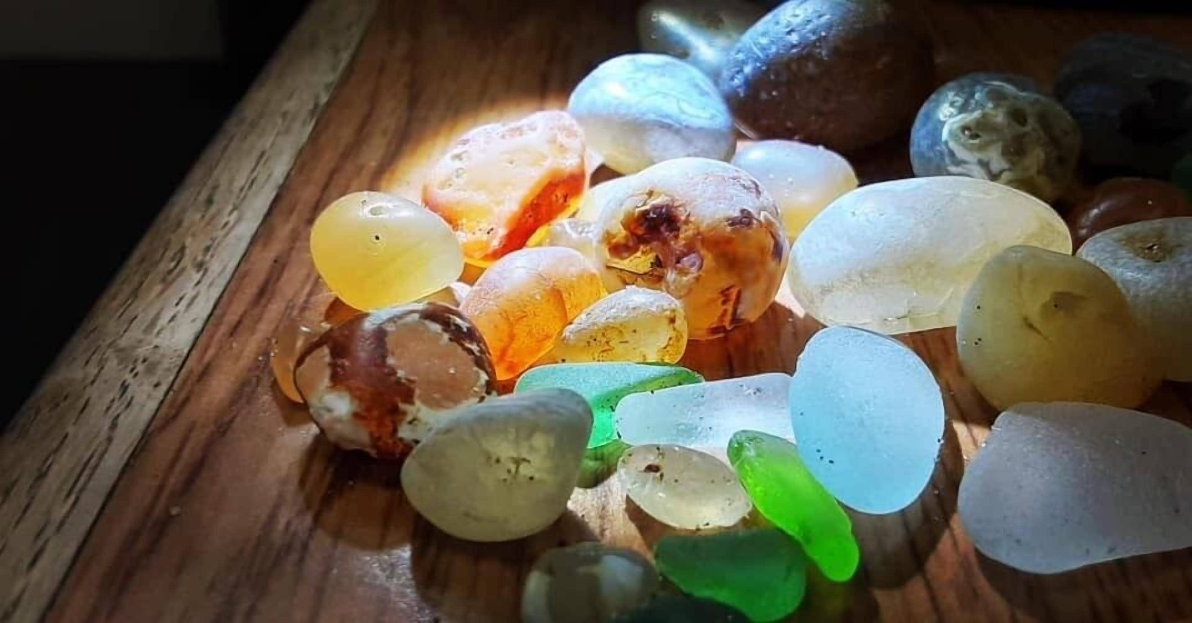 Una composizione di pietre di vetro trasparenti e multicolore su una superficie in legno.