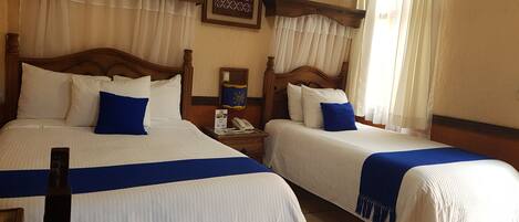 Two single beds with wooden headboards, white bedding, and blue accents.