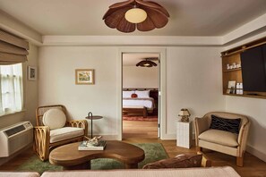 Una sala acogedora con una silla de mimbre, una mesa de centro de madera y una estantería.
