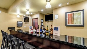 Eine Hotelbar mit einer langen Theke, verschiedenen Sitzgelegenheiten und einer Auswahl an Getränken.