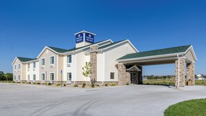 Ein Gebäude des Cobblestone Inn & Suites mit überdachter Eingangspartie und Parkplatz.