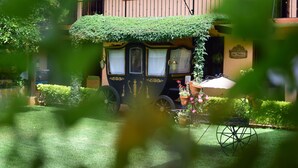 A carriage with a green roof parked in front of a building with a sign that reads "San Francisco." - Nuestras Raices - Hotel Museo Restaurante (San Cristóbal de las Casas)