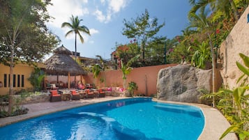 Una piscina al aire libre, camas de piscina gratis, sombrillas