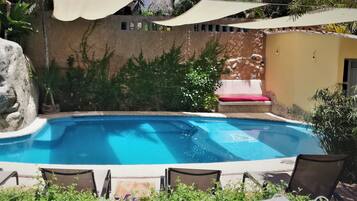 Una piscina al aire libre, camas de piscina gratis, sombrillas