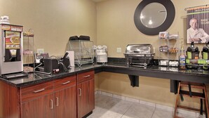 A kitchenette with a coffee machine, toaster, and food storage.